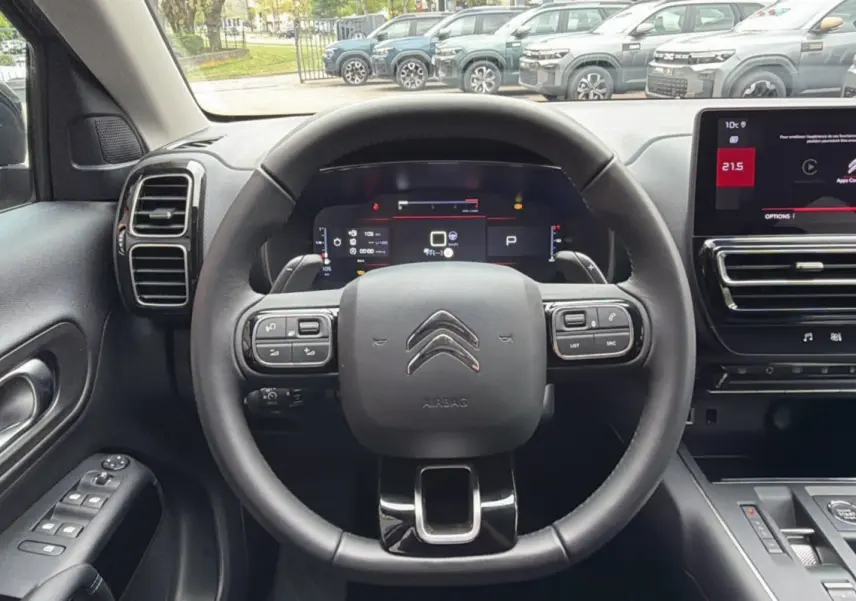 Vue intérieure centrée sur le volant cuir multifonctions d'un Citroën C5 Aircross 2025, avec tableau de bord digital.
