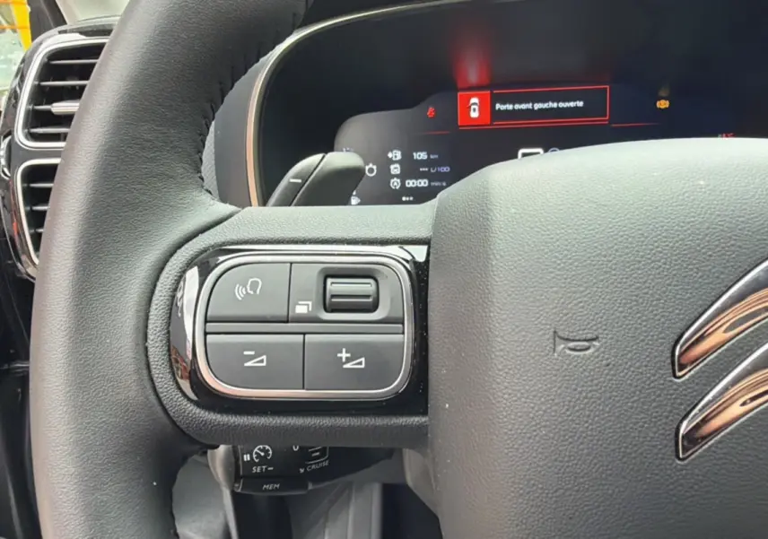 Gros plan sur le volant cuir multifonctions du Citroën C5 Aircross 2025, affichage digital et commandes intégrées visibles.