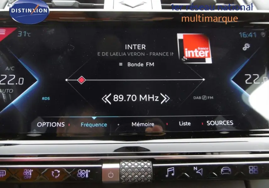 Écran tactile central du DS7 Crossback 2021 affichant la radio FM sur fond noir avec commandes chromées en dessous.