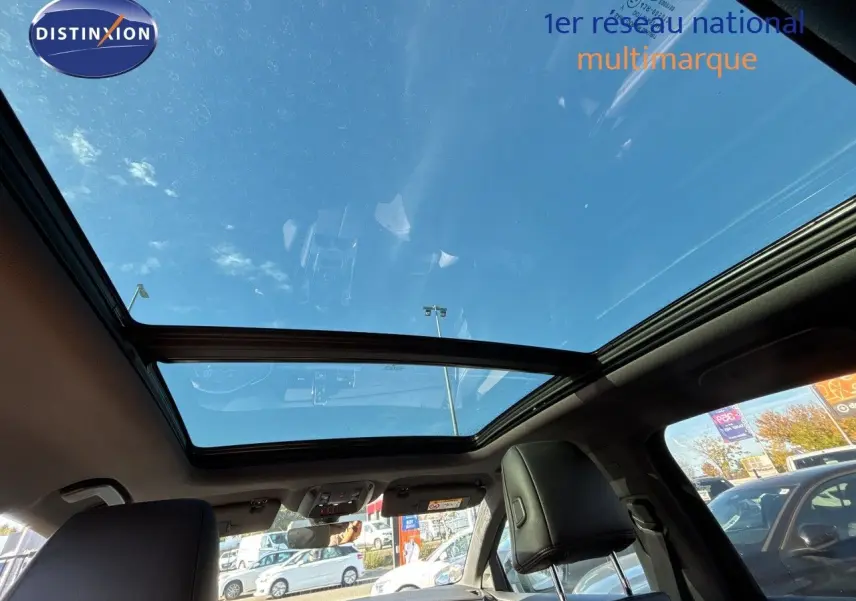 Toit panoramique en verre vu de l'intérieur arrière du DS7 Crossback E-TENSE 2021 avec ciel bleu visible.