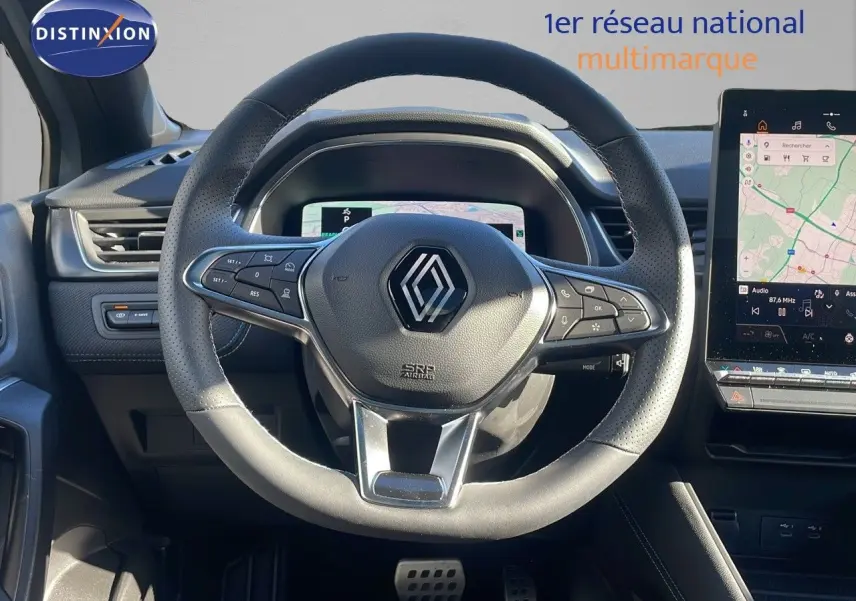 Vue intérieure centrée sur le volant du Renault Captur E-Tech hybride 2025 avec tableau de bord numérique et écran tactile.