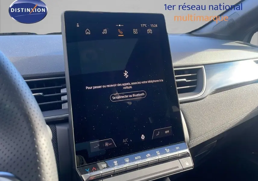 Vue intérieure du tableau de bord du Renault Captur E-Tech hybride 2025 avec écran tactile central vertical et garniture tissu gris.