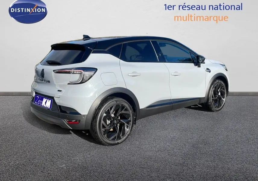 Vue 3/4 arrière droite d'un Renault Captur E-Tech hybride 2025 blanc avec toit noir et jantes noires.
