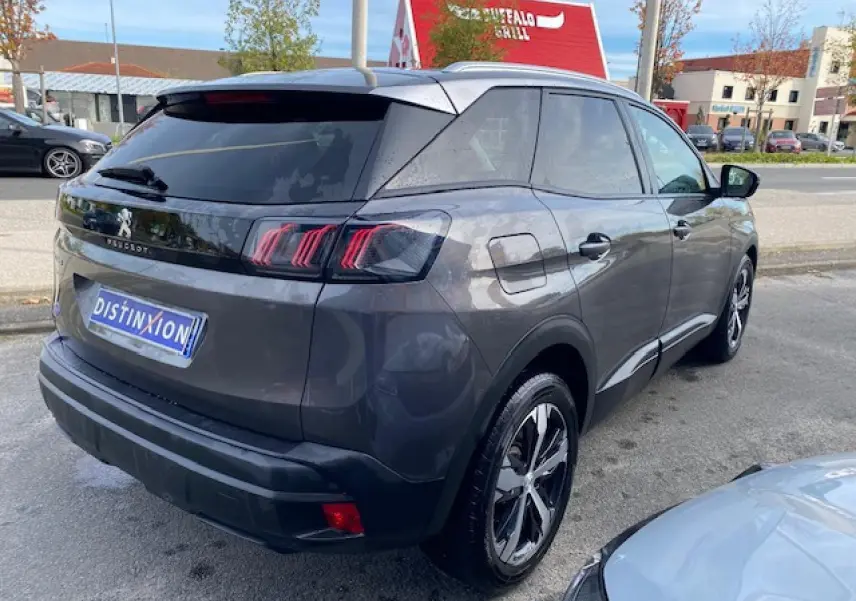 Vue 3/4 arrière droite d'un Peugeot 3008 gris platinium avec jantes alliage bi-ton et vitres surteintées.