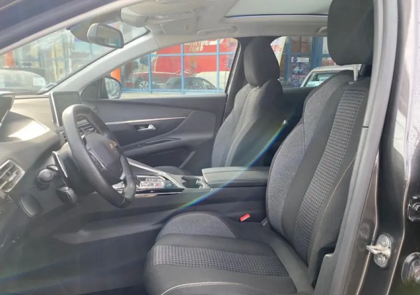 Intérieur du Peugeot 3008 gris platinium, vue côté gauche sur les sièges avant et le tableau de bord moderne.