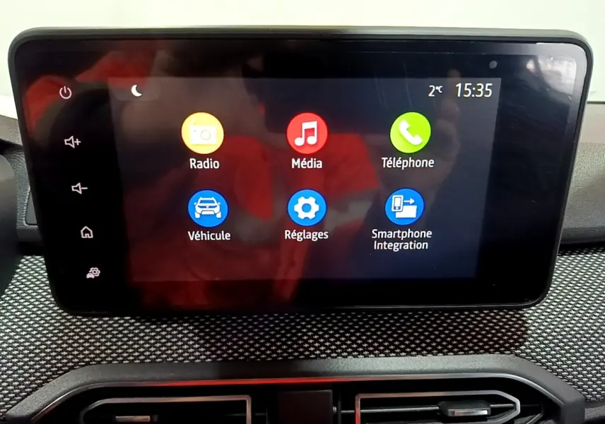 Écran tactile central de la Dacia Sandero blanc 2022 affichant les menus Radio, Média, Téléphone, Véhicule, Réglages et Smartphone Integration.