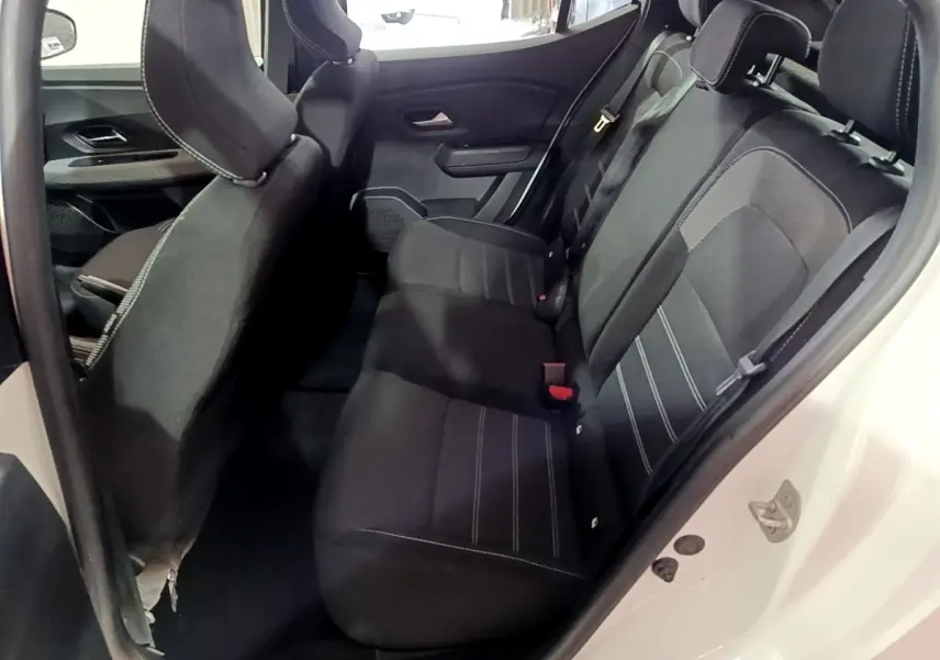Vue intérieure côté droit sur la banquette arrière noire avec surpiqûres blanches d'une Dacia Sandero blanc 2022.