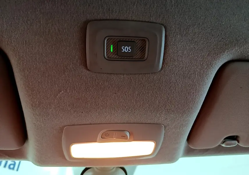 Vue intérieure du plafond avant d'une Dacia Sandero blanc 2022, avec bouton SOS et éclairage intérieur allumé.