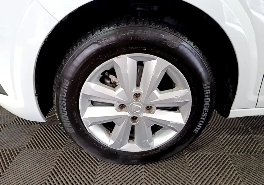 Gros plan sur la roue avant droite blanche d'une Dacia Sandero 2022 avec jante en alliage et pneu Bridgestone.
