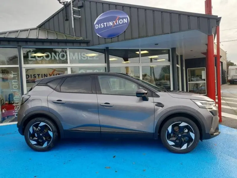 Renault Captur 2025 gris Cassiopée en profil droit, avec jantes alu noires et toit noir contrasté.