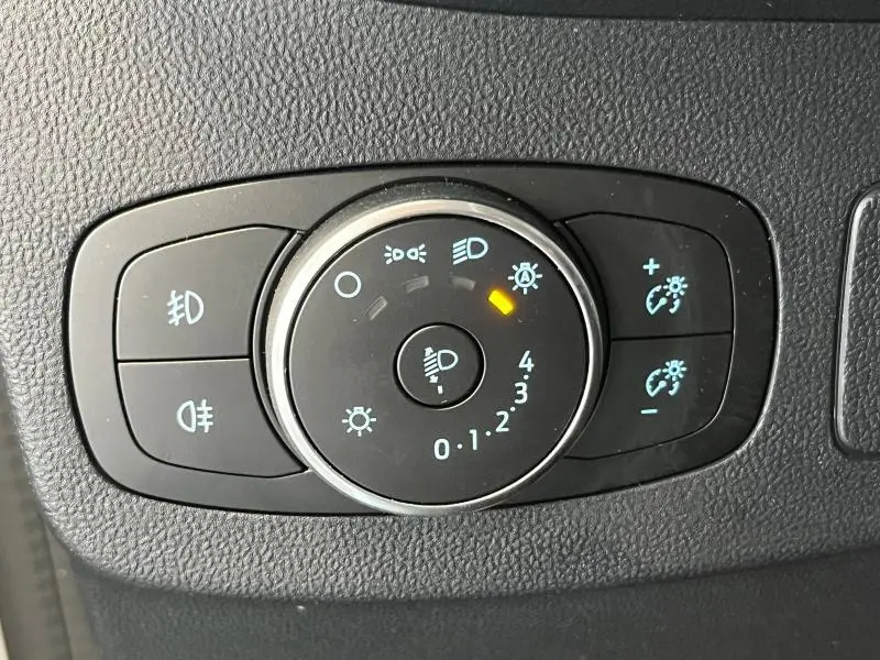 Gros plan sur la molette de réglage des phares du Ford Puma gris Solar, avec indicateur orange allumé.