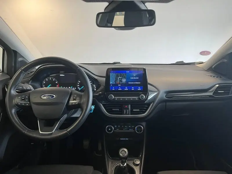 Vue intérieure du tableau de bord du Ford Puma gris, avec volant cuir multifonction et écran tactile GPS central.