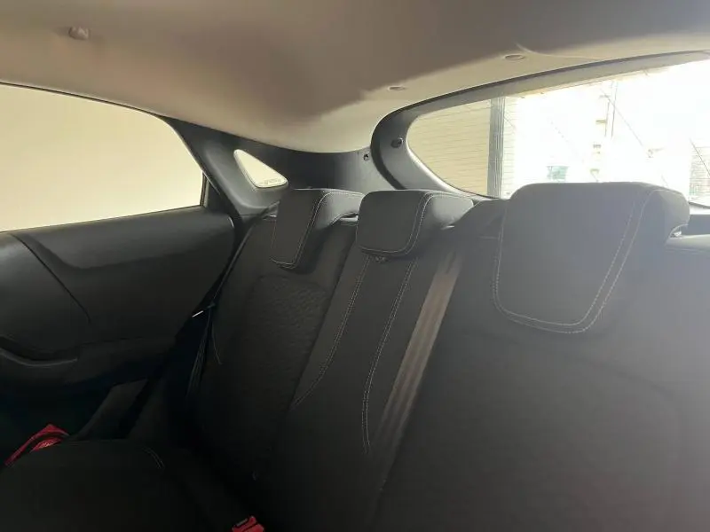 Vue intérieure arrière du Ford Puma 2021 montrant les sièges arrière noirs avec surpiqûres blanches et ceinture de sécurité.