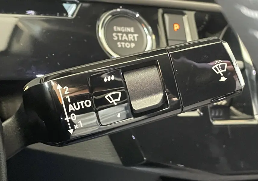 Gros plan sur la commande de l'essuie-glace du Peugeot 3008 noir, avec bouton start/stop en arrière-plan.