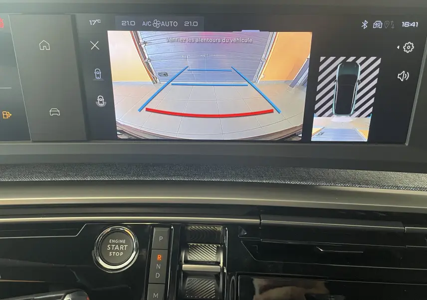 Vue intérieure du tableau de bord du Peugeot 3008 noir 2025, écran tactile affichant la caméra de recul et commandes de boîte auto.