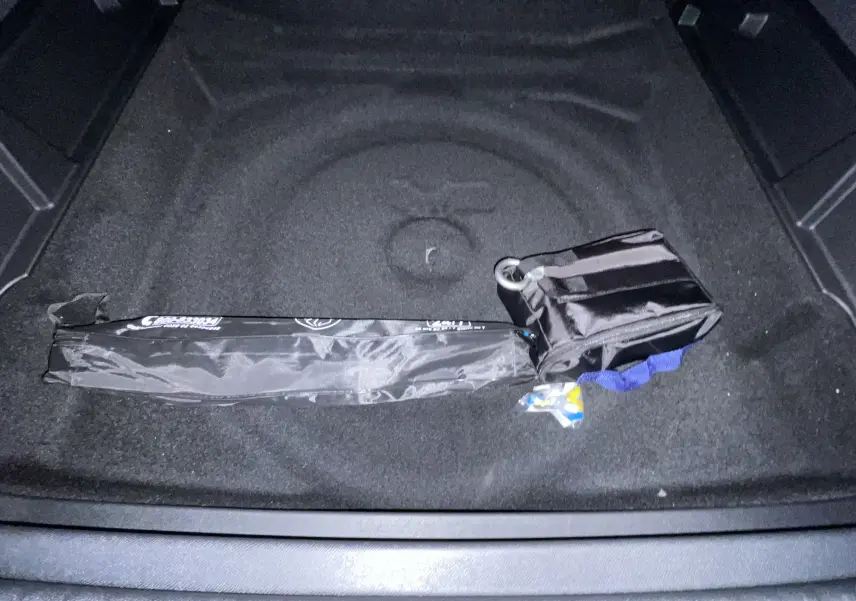 Coffre noir du Peugeot 3008 NV HYBRID 136 E-DCS6 Allure avec kit de dépannage pneumatique rangé.