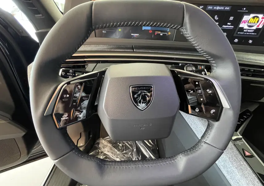 Vue rapprochée du volant cuir noir du Peugeot 3008 2025 avec commandes intégrées et tableau de bord numérique.