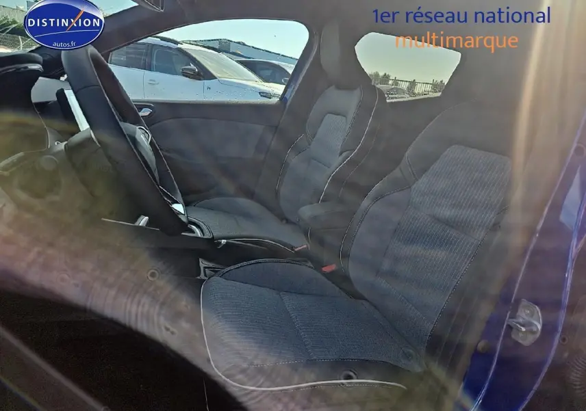 Intérieur de la Renault Clio V 1.6 e-tech 145 techno, sièges sport gris et bleu iron visible côté gauche ouvert.