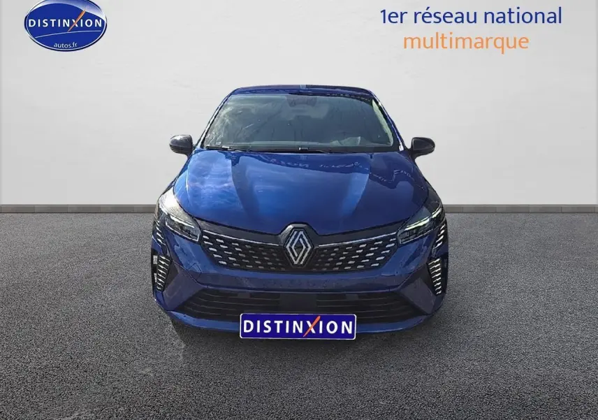 Vue frontale d'une Renault Clio V bleu iron avec calandre chromée et feux LED allumés sur fond neutre.