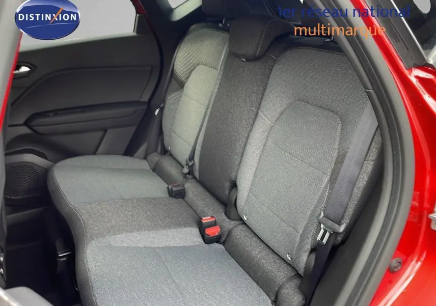 Vue intérieure sur les sièges arrière gris d'un Renault Captur rouge passion avec porte arrière ouverte côté droit.