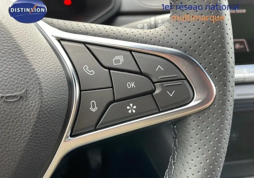 Gros plan sur les commandes multifonctions à droite du volant perforé du Renault Captur E-Tech hybride 2025.