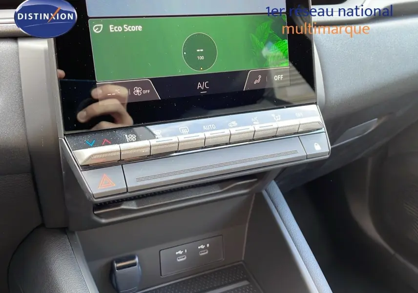 Vue rapprochée de la console centrale du Renault Captur E-Tech hybride 2025 avec écran tactile et commandes climatisation.