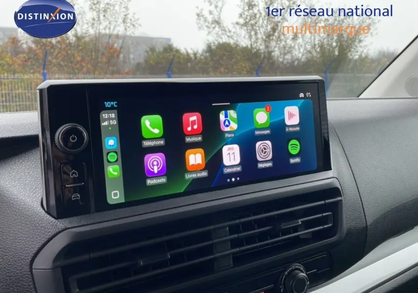 Tableau de bord du Citroën Jumpy 2025 avec écran tactile large affichant applications, ambiance intérieure noire.