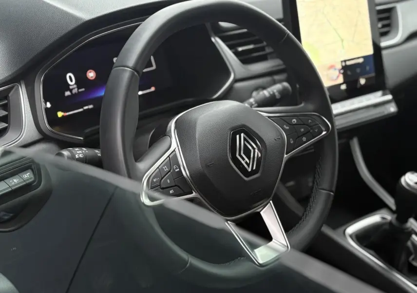 Vue rapprochée du volant noir du Renault Captur 2025 avec tableau de bord numérique et écran tactile vertical.