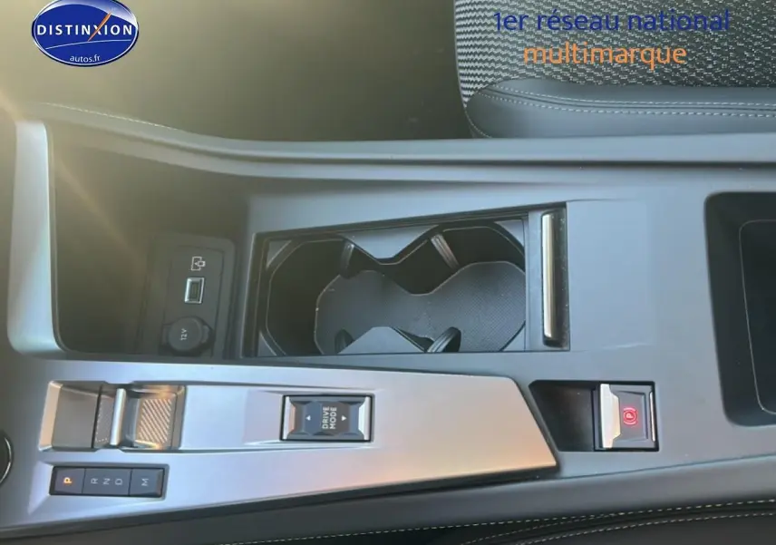 Vue plongeante sur la console centrale grise du Peugeot 408 Hybrid 145 GT avec porte-gobelets et commandes de boîte auto.