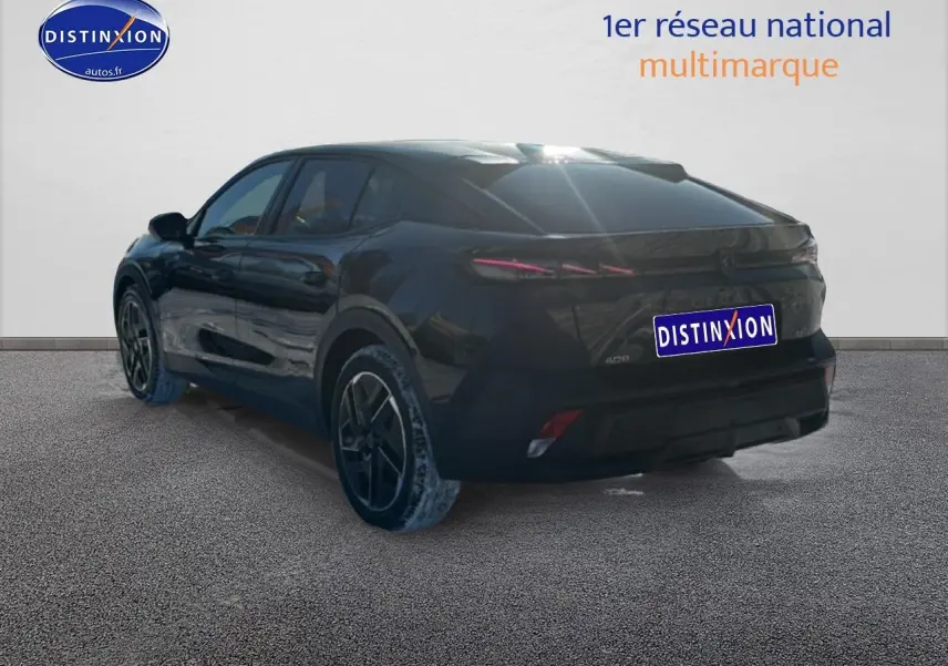 Vue 3/4 arrière gauche d'une Peugeot 408 Hybrid 145 GT noire avec jantes alu et vitres surteintées.