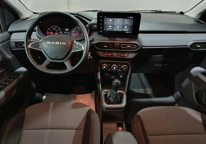 Vue intérieure avant de la Dacia Sandero 2024 avec volant cuir multifonctions et écran tactile central.