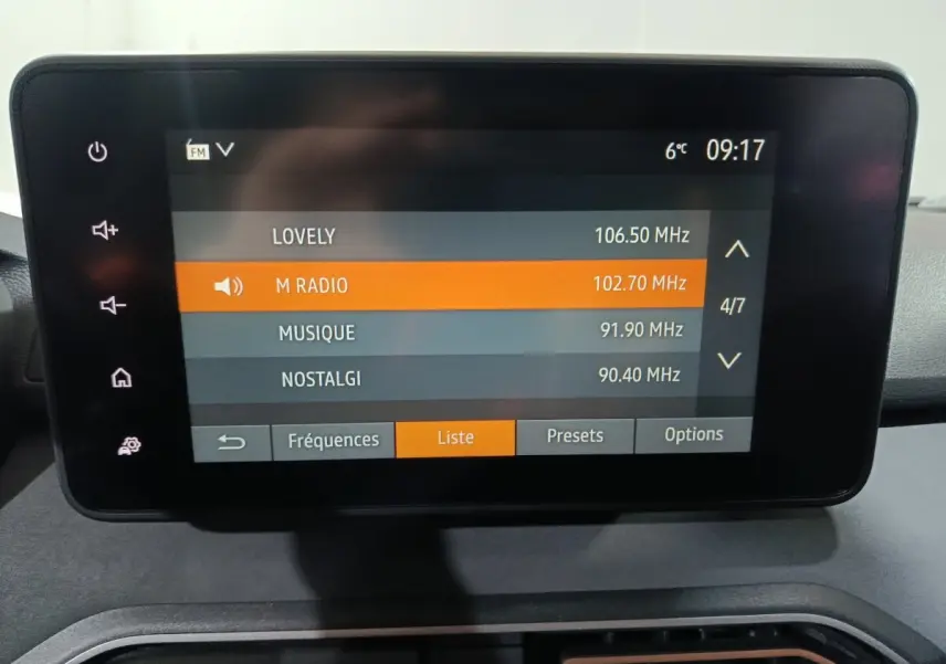 Écran tactile central de la Dacia Sandero 2024 affichant la liste des radios FM avec sélection sur M Radio.