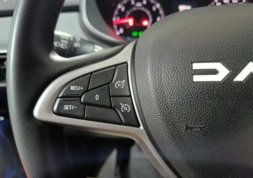 Gros plan sur le volant multifonctions en cuir synthétique de la Dacia Sandero Extreme+ TCe 110 2024, côté gauche.