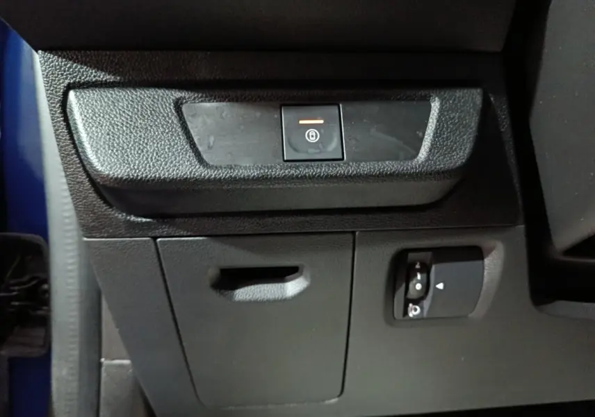 Détail intérieur du tableau de bord côté conducteur de la Dacia Sandero Extreme+ bleu, avec bouton de verrouillage centralisé.