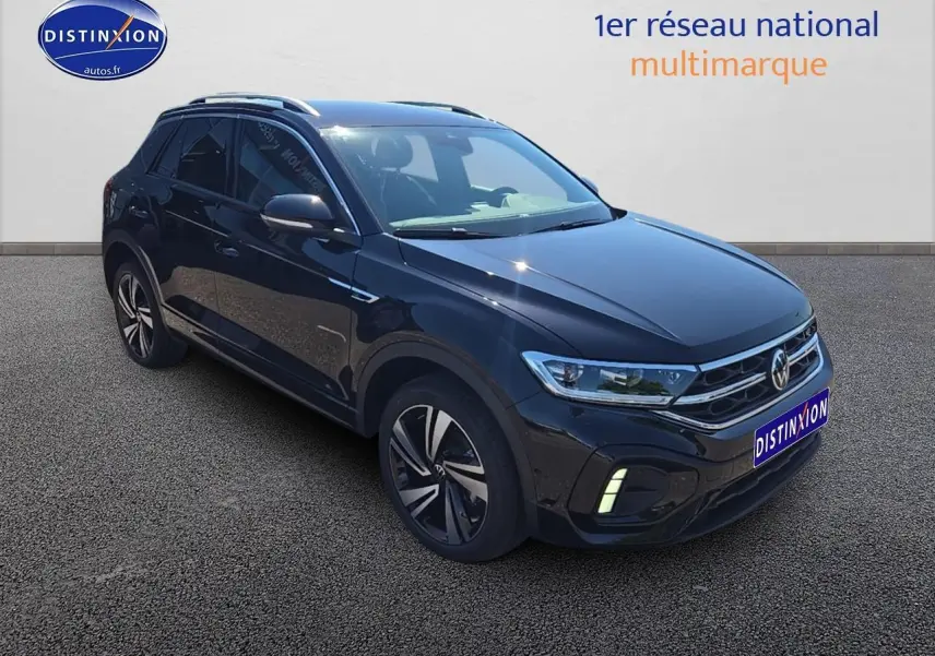 Volkswagen T-Roc noir perle en 3/4 avant droit avec jantes alliage et barres de toit argentées visibles.