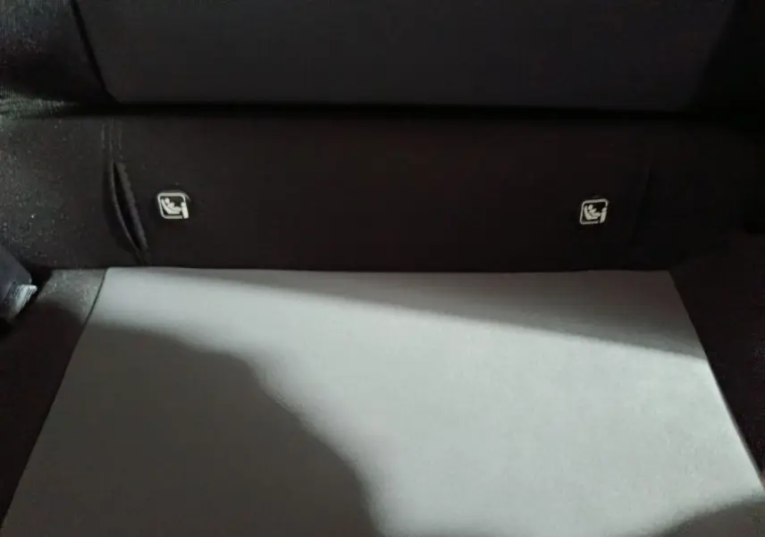 Détail du coffre intérieur noir de la Dacia Sandero Extreme+ TCe 110 avec fixations Isofix visibles sur la banquette arrière.