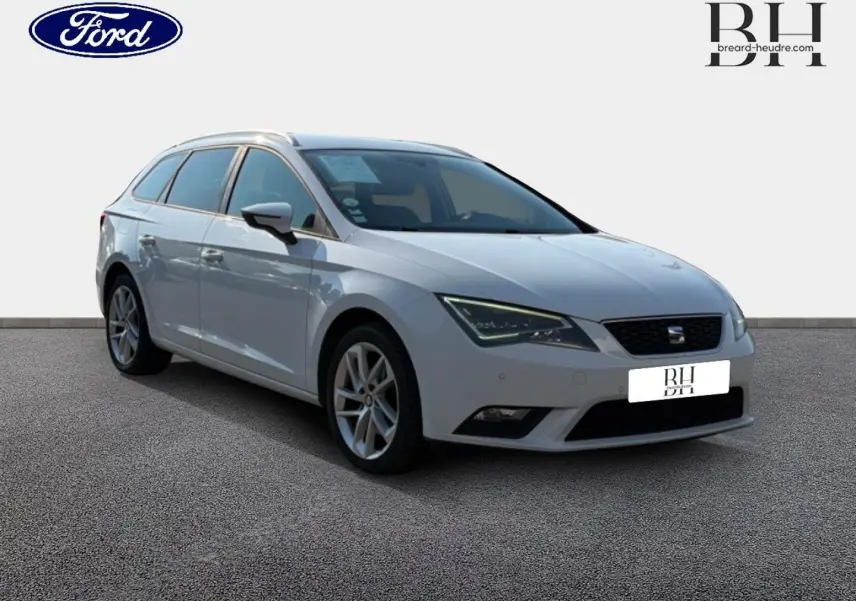SEAT Leon ST gris étoile vue 3/4 avant droit, break compact avec jantes alliage et barres de toit visibles.