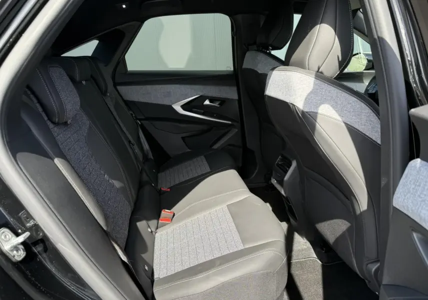 Vue côté gauche de l'habitacle arrière du Peugeot 3008 Hybrid 145 Allure noir Perla avec sellerie tissu et cuir gris clair.