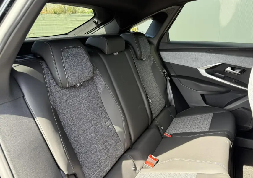 Vue latérale droite des sièges arrière en tissu gris et cuir noir du Peugeot 3008 Hybrid 145 e-DSC6 Allure 2025.