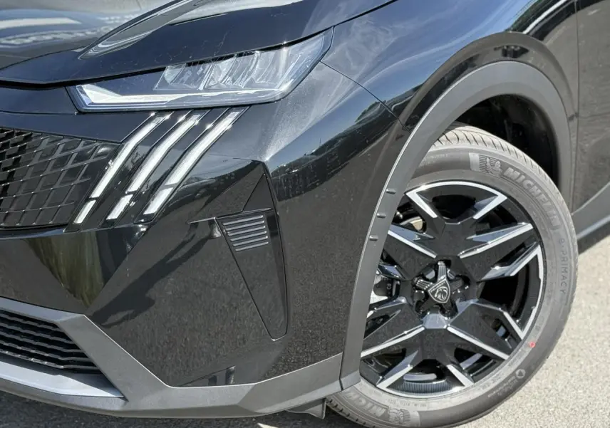 Gros plan sur l'avant droit noir Perla du Peugeot 3008 Hybrid 145 Allure, mettant en valeur les feux LED et la jante alliage 19''.