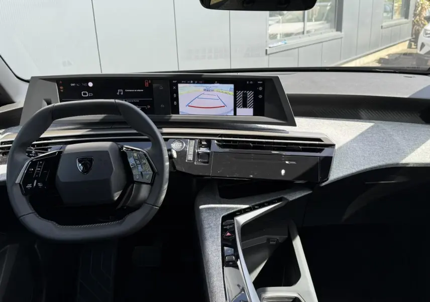 Intérieur Peugeot 3008 Hybrid 2025 vu de face, tableau de bord avec double écran HD et volant compact cuir noir.