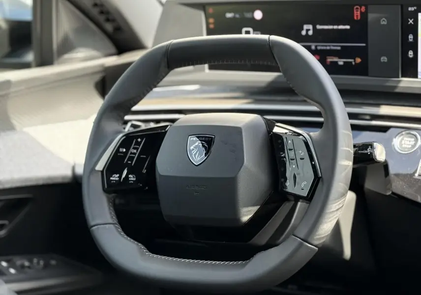 Volant compact en cuir noir avec commandes intégrées du Peugeot 3008 Hybrid 145, vue rapprochée du poste de conduite.