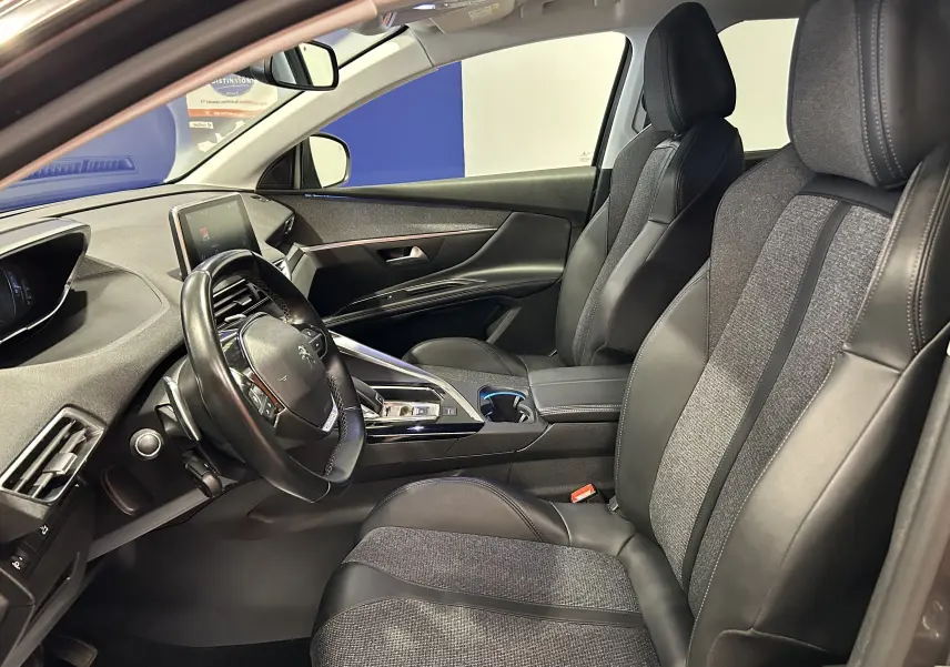 Intérieur avant du Peugeot 5008 gris 2020, sièges chauffants en cuir et tissu, tableau de bord moderne avec écran tactile.