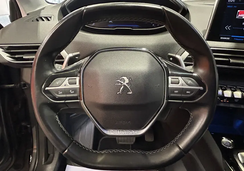 Volant en cuir noir de Peugeot 5008 2020 avec commandes intégrées, tableau de bord et écran tactile visibles en arrière-plan.
