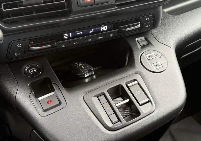 Vue rapprochée de la console centrale noire du Peugeot Partner 2025 avec commandes de boîte auto et démarrage sans clé.
