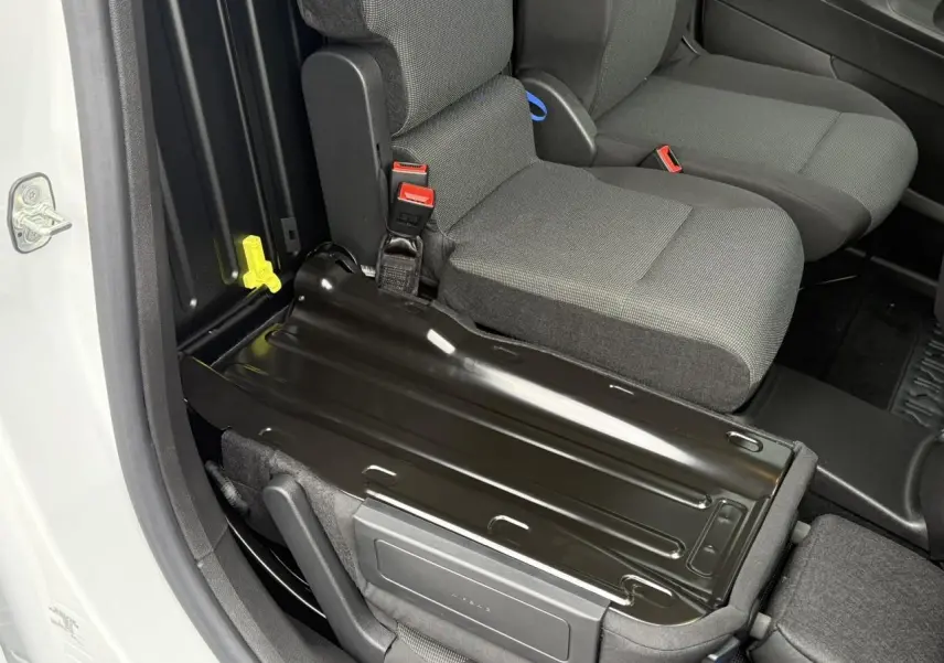 Détail de la banquette passager rabattue côté droit dans l'habitacle gris du Peugeot Partner blanc 2025