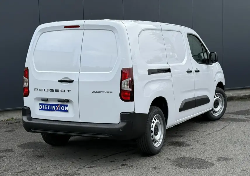 Vue 3/4 arrière droite d'un utilitaire Peugeot Partner blanc avec porte latérale coulissante et pare-chocs noirs.