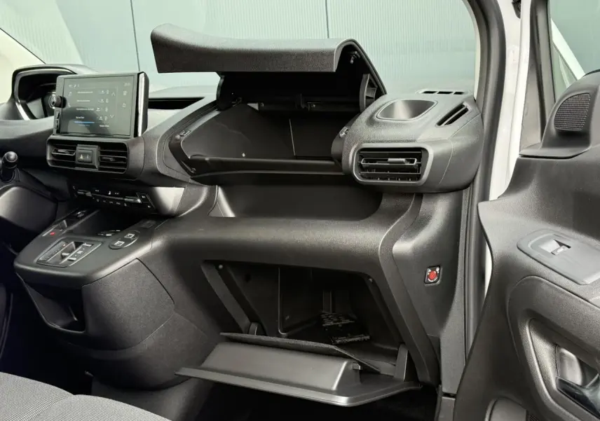 Intérieur côté passager du Peugeot Partner 2025 blanc, montrant tableau de bord et double boîte à gants ouvertes.