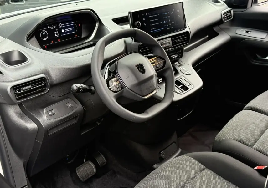 Vue intérieure côté conducteur du Peugeot Partner 2025 avec tableau de bord numérique et écran tactile central.