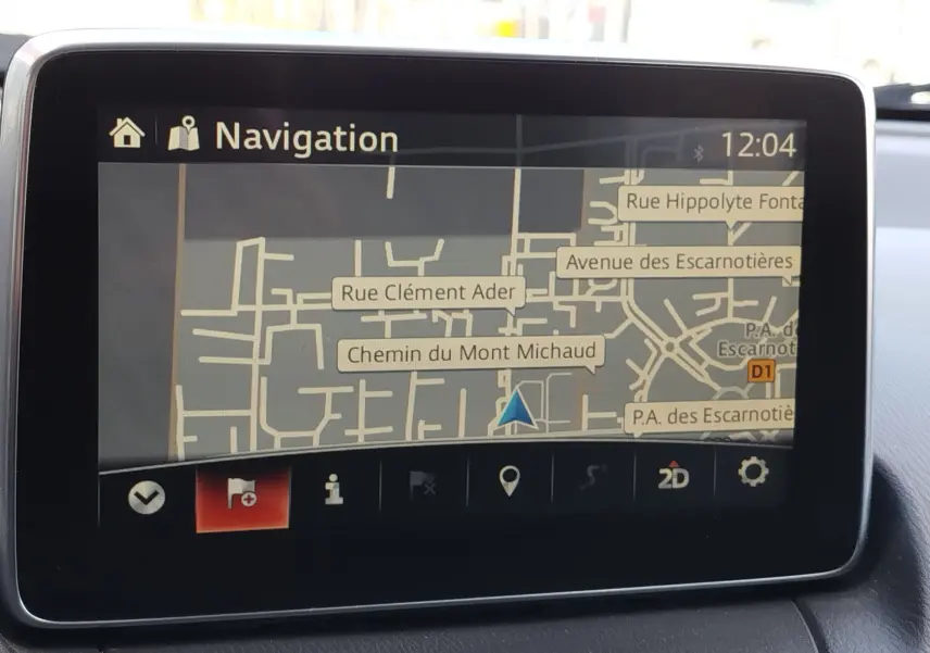 Écran de navigation du Mazda CX-3 2016 affichant une carte détaillée avec rues et options en bas de l'écran.